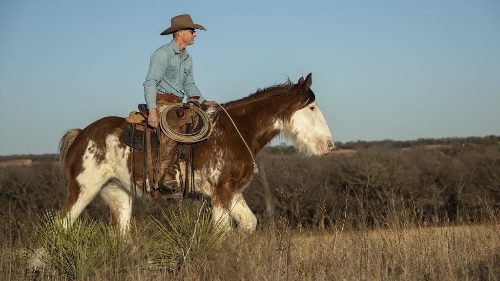 Ty Murray and Sioux riding in a pasture.